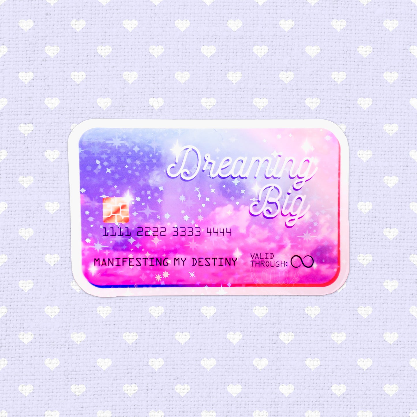 Holographic sticker designed as a credit card with the phrase 'Dreaming Big - Manifesting My Destiny', filled with vibrant colors and starry motifs, ideal for adding an inspirational touch to any item.