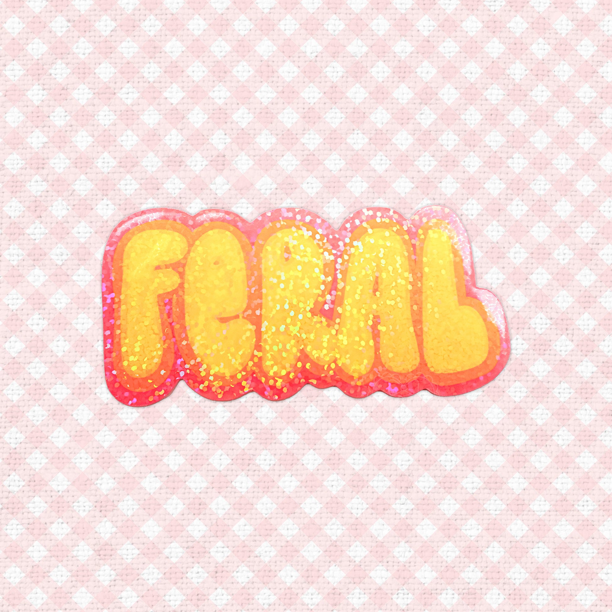 A holographic sticker with the word "Feral" in bold, glittery orange and red letters.