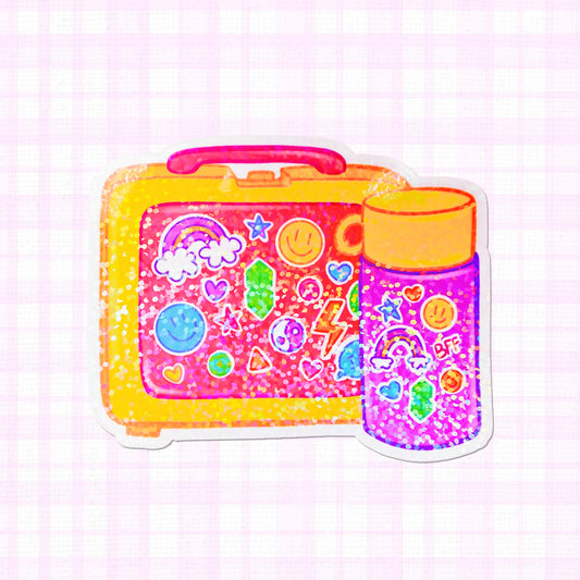 Colorful holographic sticker of a vintage lunchbox filled with vibrant icons and a juice bottle.